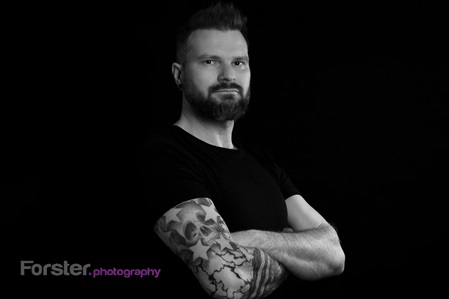 Junger Mann mit schwarzem Shirt lächelt in die Kamera beim Fotoshooting in Iserlohn