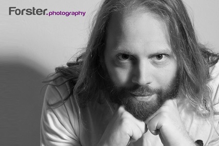 Junger Mann mit langen Haaren lächelt in die Kamera beim Fotoshooting in Iserlohn