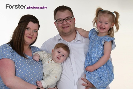 Junges Paar mit Tochter lächelt in die Kamera beim Fotoshooting in Iserlohn