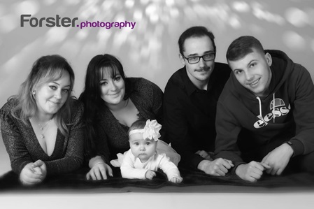 Junge Familie mit Baby lächelt in die Kamera beim Fotoshooting in Iserlohn