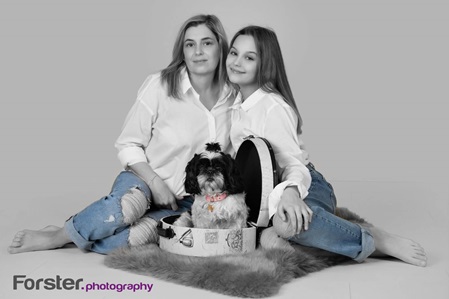 Junge Mutter mit Tochter und Hund lächelt beim Fotoshooting in Iserlohn in die Kamera