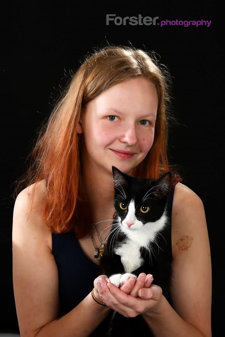 Junge Frau mit 2 schwarz-weißer Katze lächelt beim Fotoshooting in Iserlohn in die Kamera