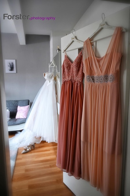 Ein Brautkleid hängt beim getting ready Fotoshooting am Kleiderschrank bereit