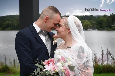 Hochzeitspaar schaut sich beim Braut-Fotoshooting innig und verliebt in die Augen vor einem See