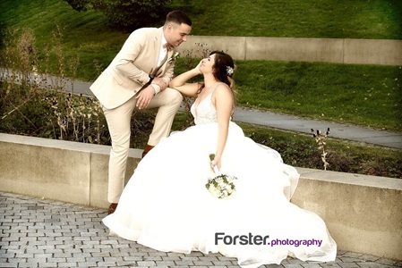 Ein Hochzeitspaar blickt sich beim Fotoshooting im Sauerlandpark Hemer verliebt in die Augen. Die Braut sitzt
